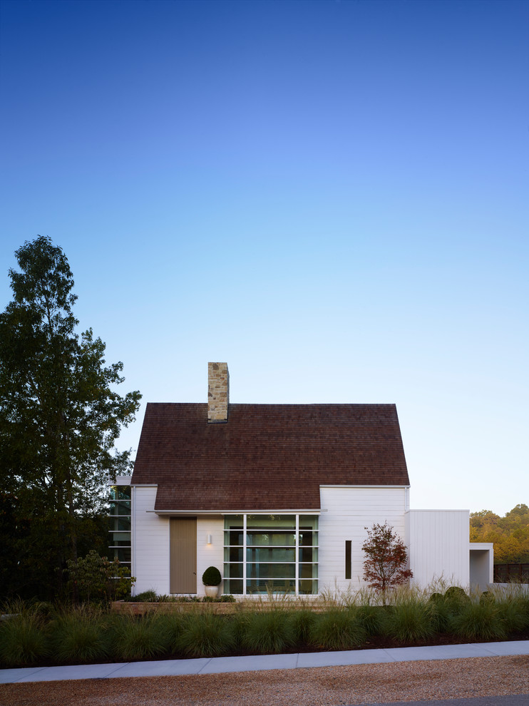 Idée de décoration pour une façade de maison blanche champêtre en brique de taille moyenne et de plain-pied avec un toit à quatre pans.