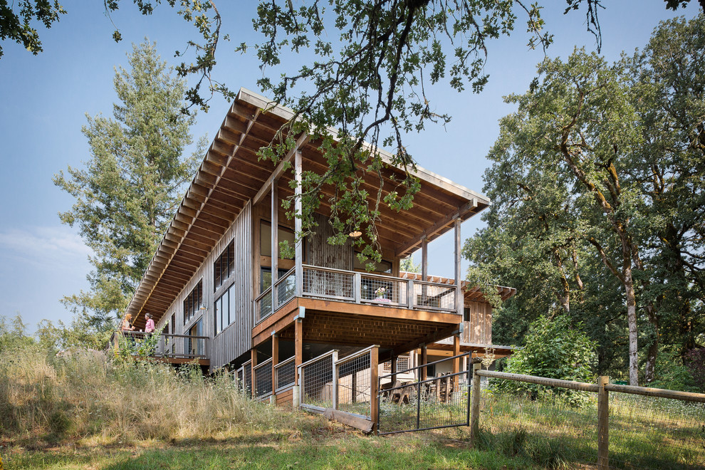 Idee per la facciata di una casa marrone country a un piano con rivestimento in legno e copertura in metallo o lamiera