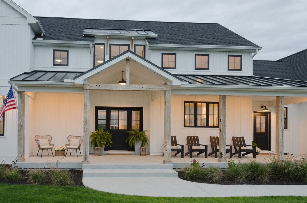 Ejemplo de fachada de casa blanca de estilo de casa de campo de tamaño medio de dos plantas con revestimiento de madera y tejado de varios materiales