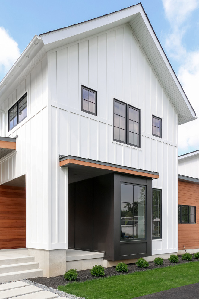 Modelo de fachada de casa blanca de estilo de casa de campo de tamaño medio de dos plantas con tejado de un solo tendido, tejado de teja de madera y revestimientos combinados