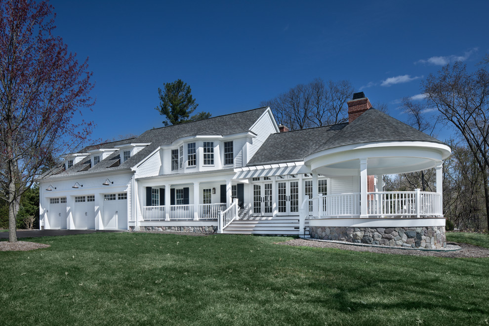Imagen de fachada de casa blanca clásica extra grande de dos plantas con revestimiento de madera, tejado de teja de madera y tejado a dos aguas