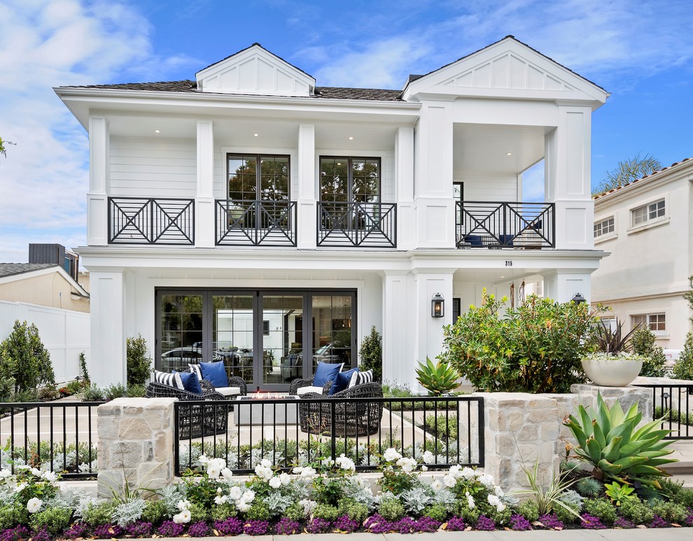 Großes, Zweistöckiges Maritimes Einfamilienhaus mit weißer Fassadenfarbe, Walmdach und Schindeldach in Orange County