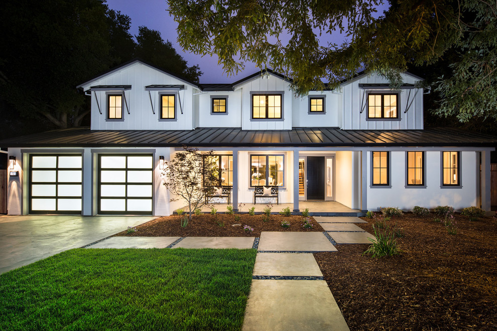 Ejemplo de fachada blanca de estilo de casa de campo de dos plantas con revestimientos combinados
