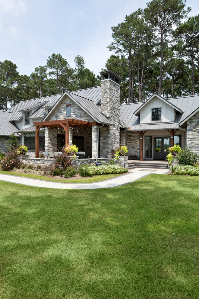 Mittelgroßes, Einstöckiges Landhaus Einfamilienhaus mit Mix-Fassade, grauer Fassadenfarbe, Satteldach und Blechdach in Houston