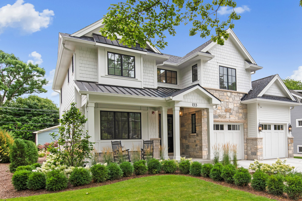 Réalisation d'une grande façade de maison blanche champêtre à un étage avec un revêtement mixte, un toit à deux pans et un toit mixte.