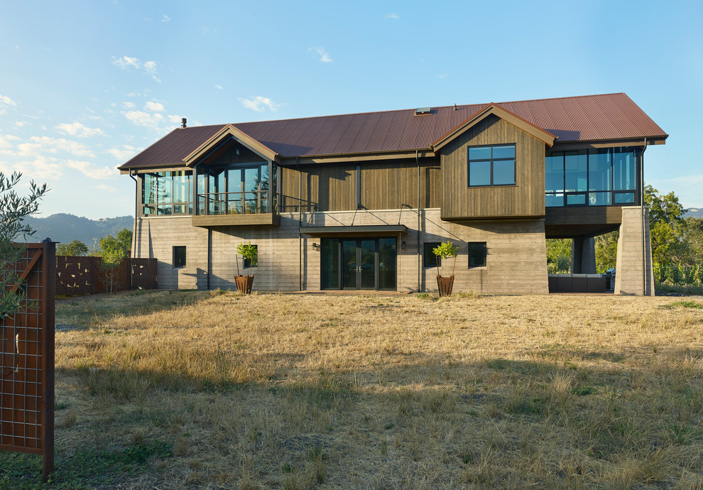 Immagine della villa grigia country a due piani con rivestimenti misti, tetto a capanna e copertura in metallo o lamiera