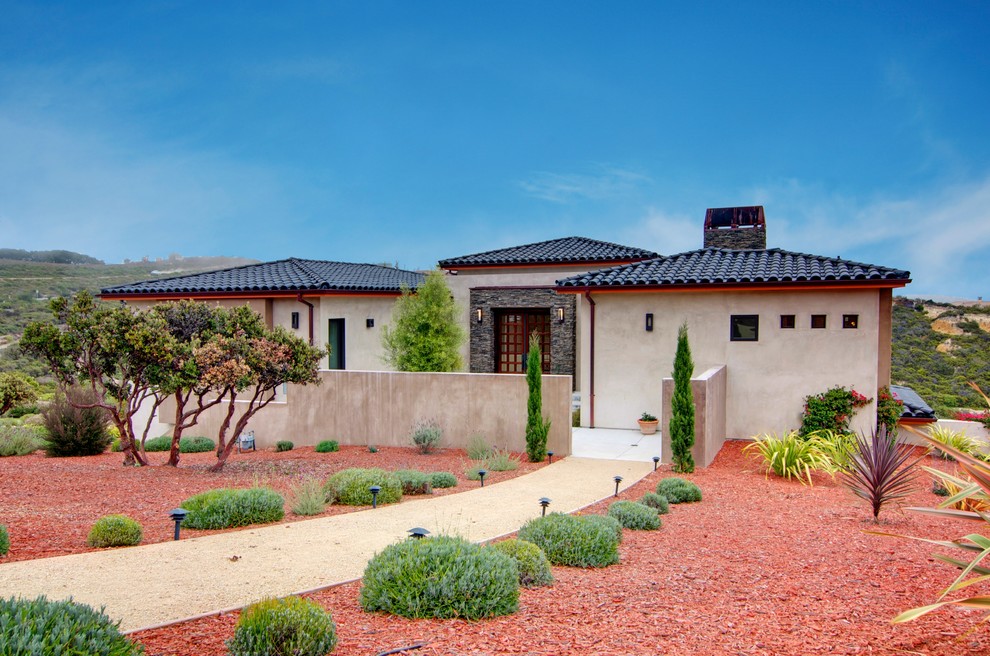 Large tuscan beige two-story stucco exterior home photo in San Francisco with a tile roof