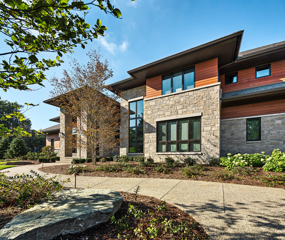 Inspiration for a large and beige contemporary two floor detached house in Detroit with wood cladding, a pitched roof and a shingle roof.