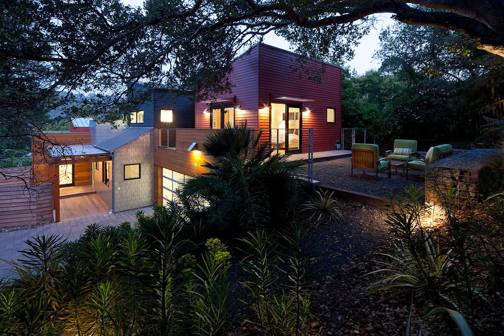Ispirazione per la facciata di una casa contemporanea con rivestimento in legno e terreno in pendenza