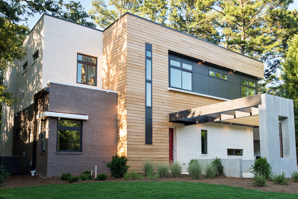 Foto della facciata di una casa moderna a due piani di medie dimensioni con rivestimento in mattoni e tetto piano
