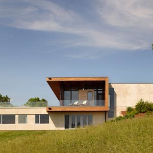 Idées déco pour une grande façade de maison beige contemporaine en bois de plain-pied avec un toit plat.