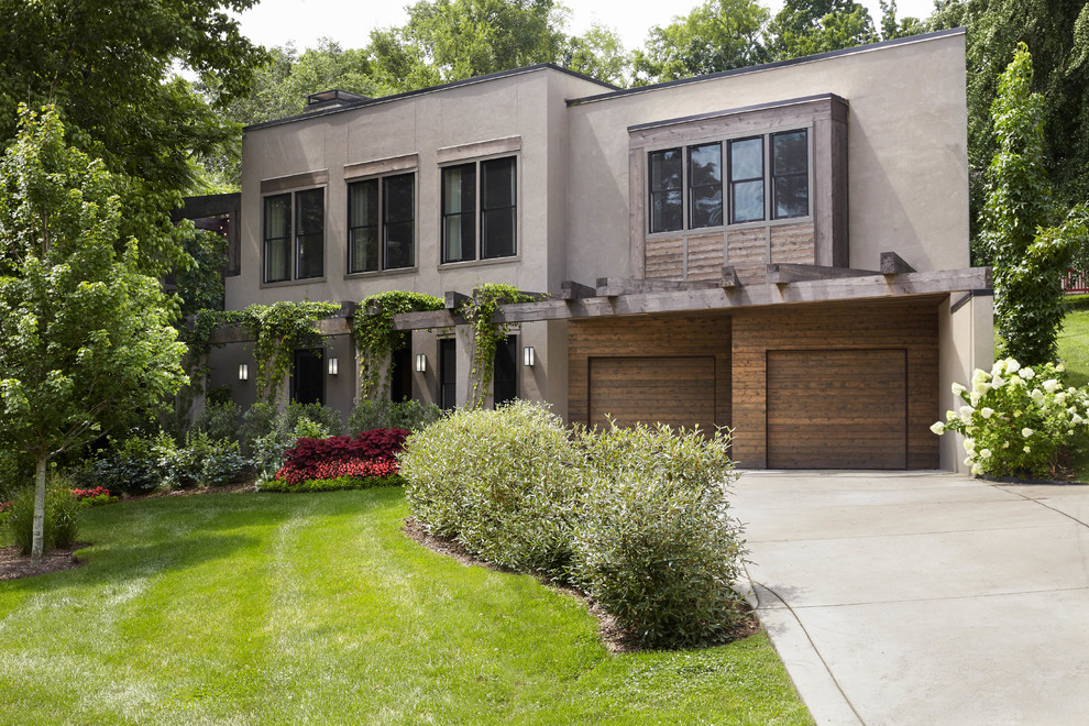 Diseño de fachada de casa marrón contemporánea grande de dos plantas con revestimiento de estuco y tejado plano