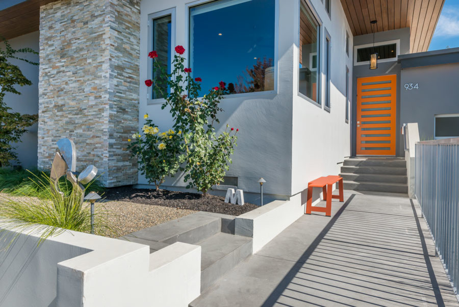 Стильный дизайн: большой, одноэтажный, серый частный загородный дом в стиле ретро с облицовкой из цементной штукатурки и плоской крышей - последний тренд
