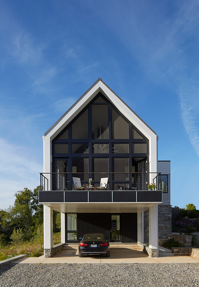 На фото: большой, двухэтажный, белый дом в современном стиле с облицовкой из камня и двускатной крышей
