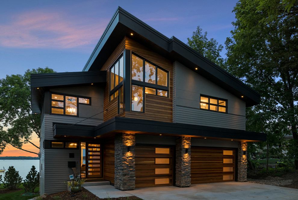 Modelo de fachada de casa multicolor moderna grande de tres plantas con revestimientos combinados y tejado de teja de madera