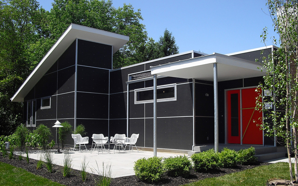 Example of a mid-century modern black one-story exterior home design in Grand Rapids