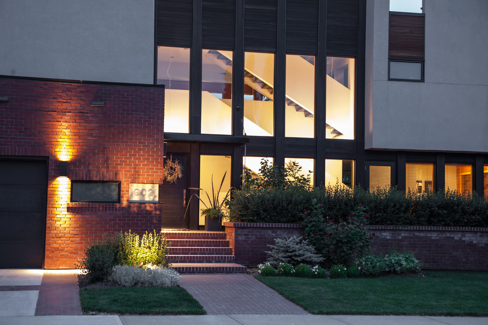 Large and red contemporary brick house exterior in Calgary with three floors.