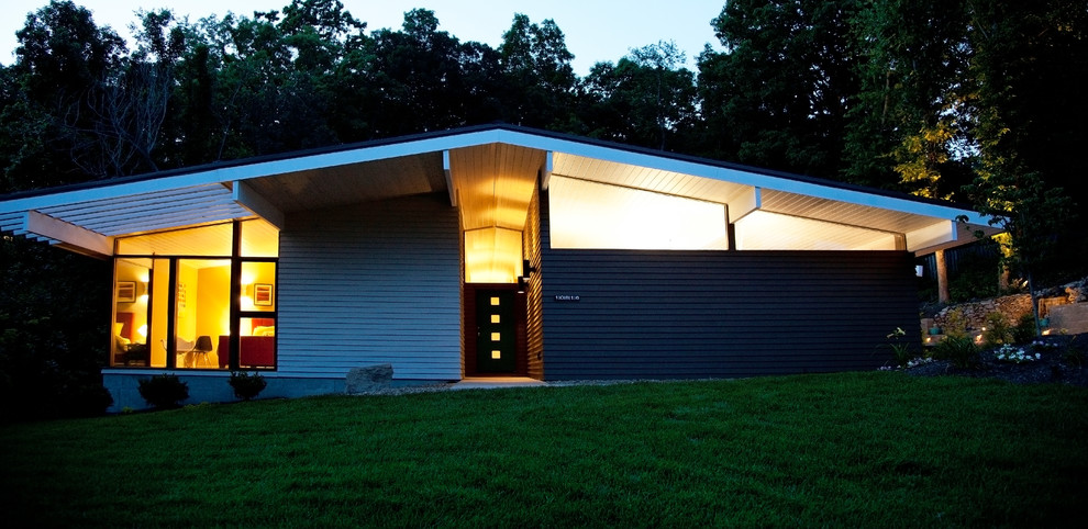 Inspiration pour une façade de maison grise vintage en panneau de béton fibré de plain-pied avec un toit à deux pans.