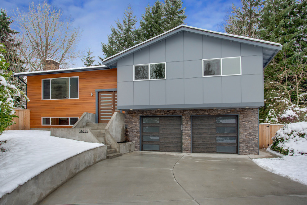 Стильный дизайн: двухэтажный, деревянный, серый дом среднего размера в стиле модернизм с двускатной крышей и отделкой планкеном - последний тренд