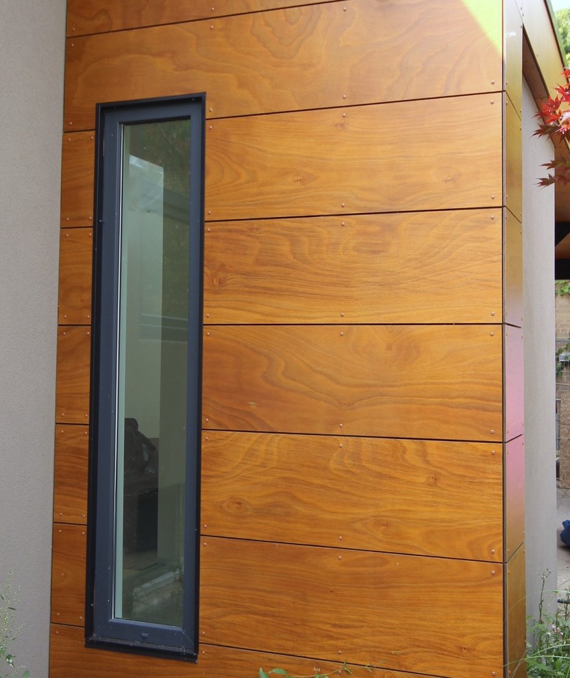 Modelo de fachada marrón minimalista de tamaño medio de dos plantas con revestimiento de madera y tejado plano