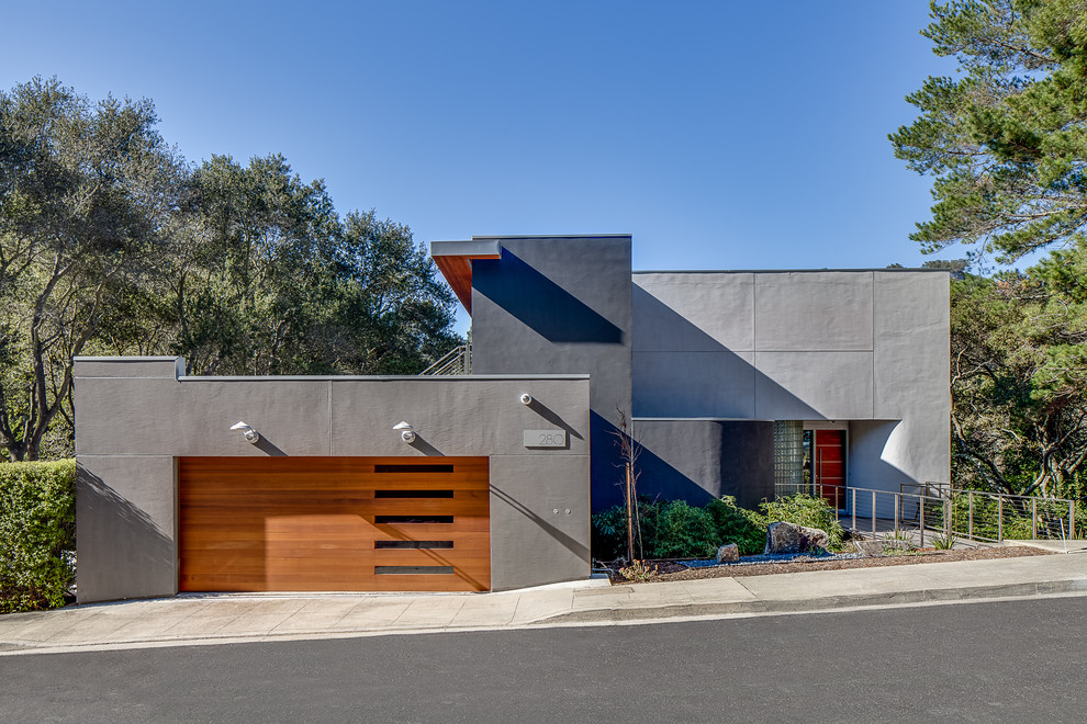 Inspiration pour une façade de maison grise minimaliste avec un toit plat.