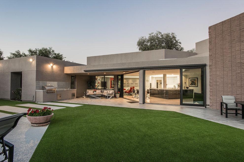 Modelo de fachada de casa gris minimalista grande de una planta con revestimiento de hormigón y tejado plano