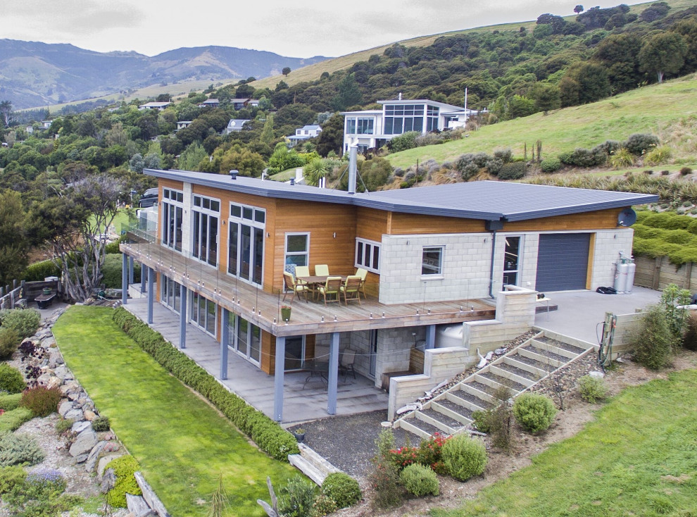 Идея дизайна: двухэтажный, разноцветный частный загородный дом в морском стиле с комбинированной облицовкой, крышей-бабочкой и металлической крышей