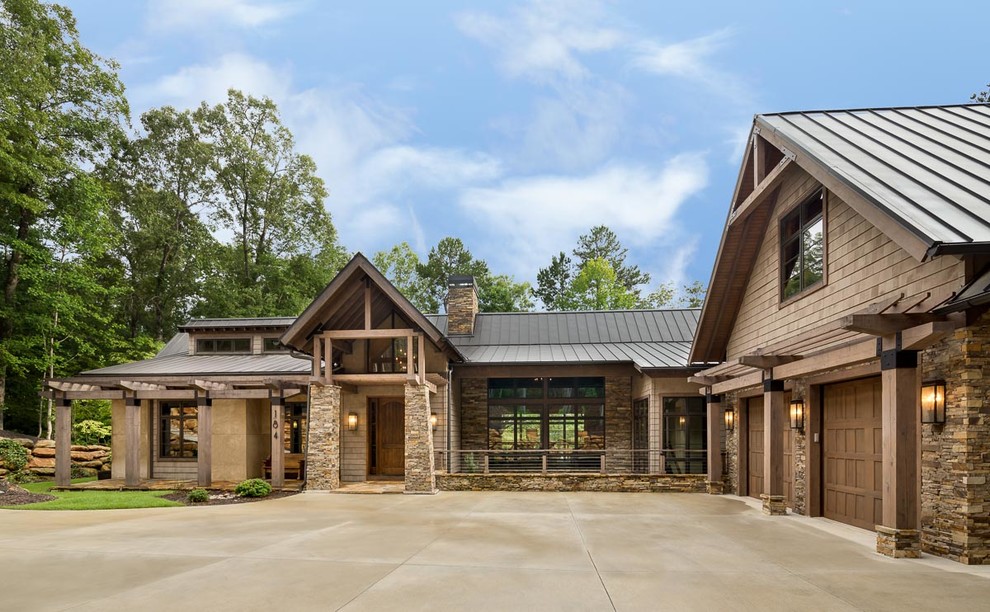 Inspiration pour une grande façade de maison marron chalet à un étage avec un revêtement mixte et un toit à deux pans.