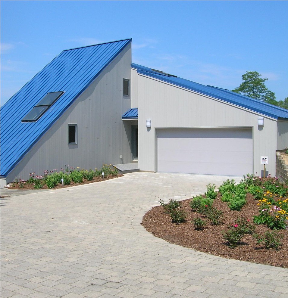 Aménagement d'une petite façade de maison contemporaine avec un toit en appentis, un toit bleu et un toit en métal.