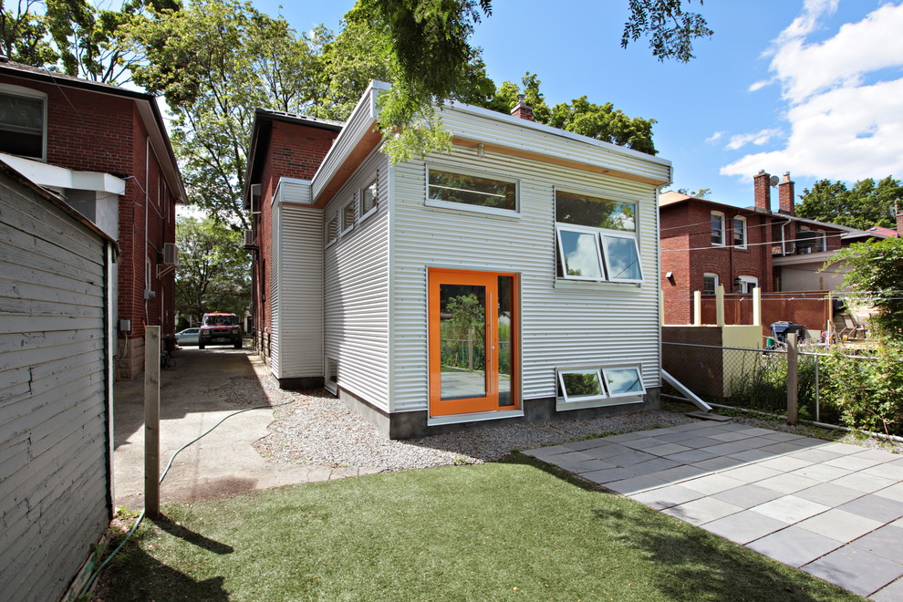 Идея дизайна: одноэтажный, серый дом среднего размера в современном стиле с облицовкой из металла и плоской крышей