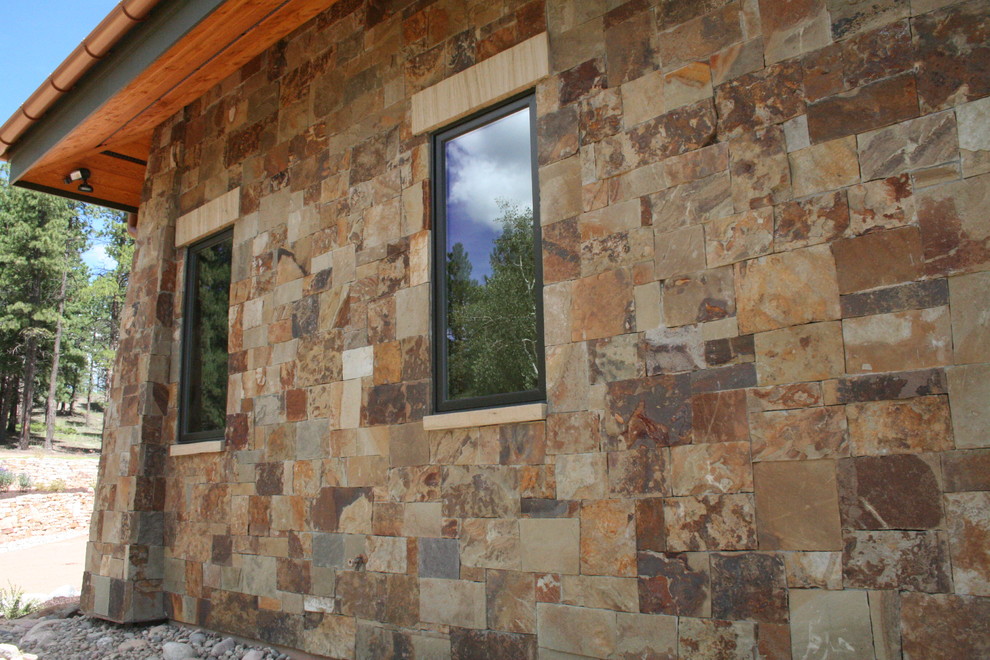 Inspiration for a rustic bungalow house exterior in Denver with stone cladding.