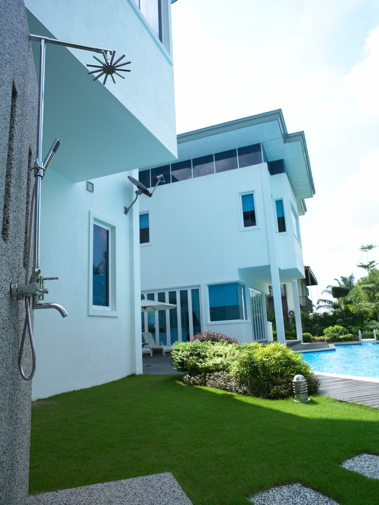 Esempio della facciata di una casa grande bianca moderna a tre piani con rivestimento in cemento e copertura in metallo o lamiera