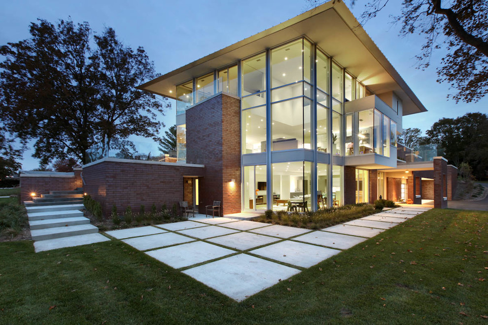 Exemple d'une grande façade de maison moderne en verre à un étage avec un toit en appentis et un toit en métal.