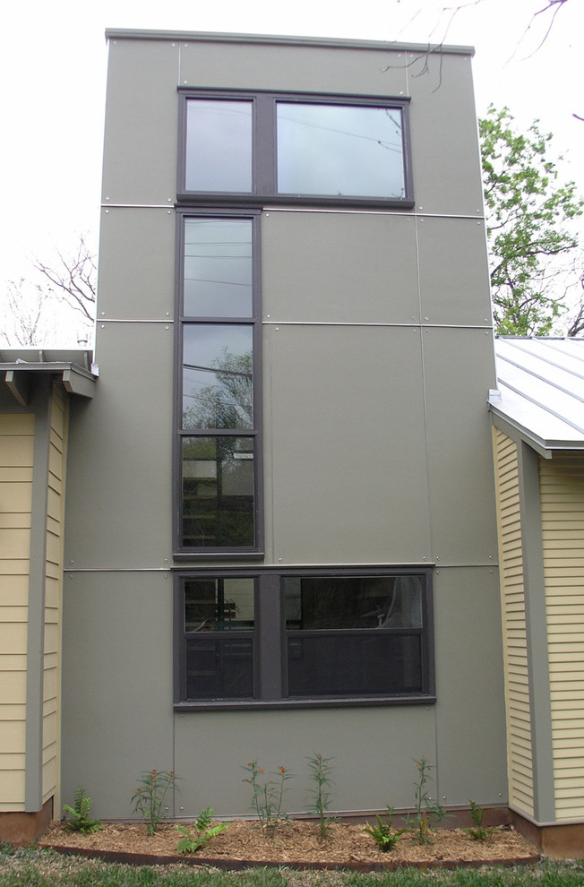 Ejemplo de fachada de casa minimalista de tamaño medio de una planta con revestimientos combinados, tejado a dos aguas y tejado de metal