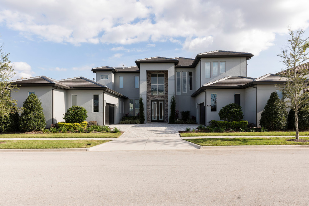 Großes, Zweistöckiges Modernes Einfamilienhaus mit Mix-Fassade, grauer Fassadenfarbe, Ziegeldach und Walmdach in Orlando