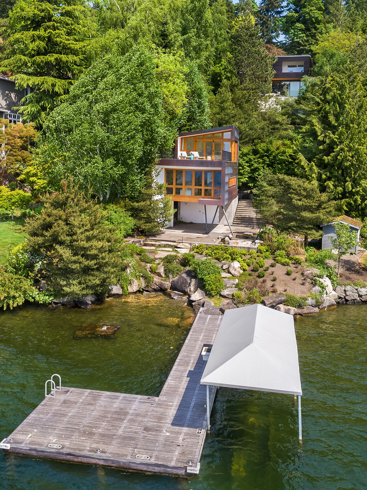 Zweistöckiges Maritimes Einfamilienhaus mit Glasfassade, brauner Fassadenfarbe und Pultdach in Seattle