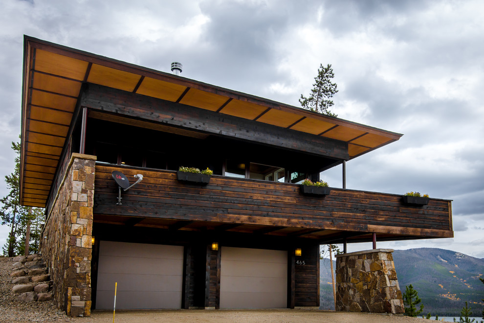 Cette image montre une façade de maison marron minimaliste en bois à un étage.
