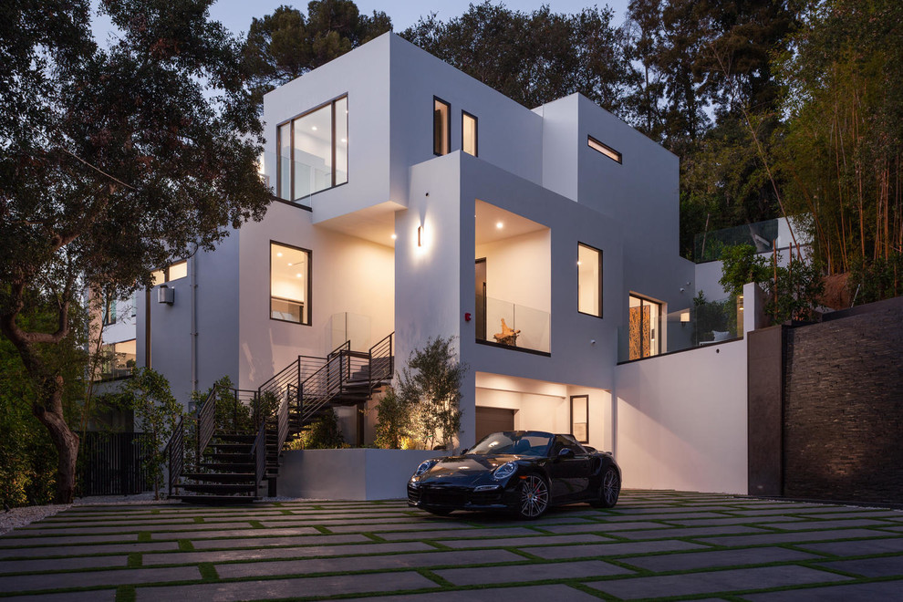 На фото: огромный, трехэтажный, белый дом в стиле модернизм с облицовкой из цементной штукатурки и плоской крышей