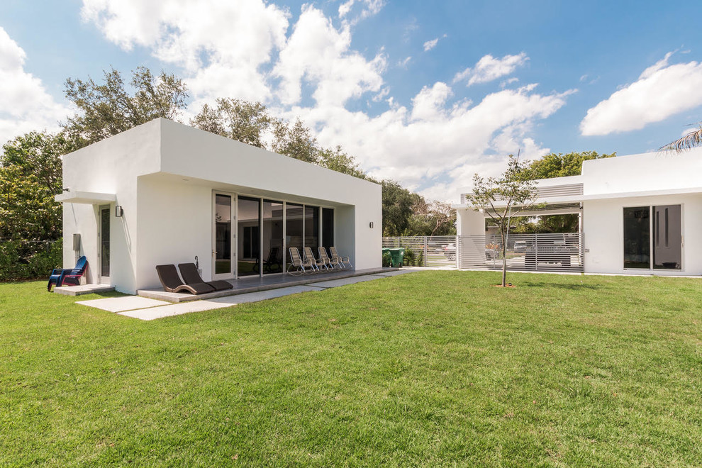 Imagen de fachada de casa blanca minimalista grande de una planta con revestimiento de hormigón y tejado plano