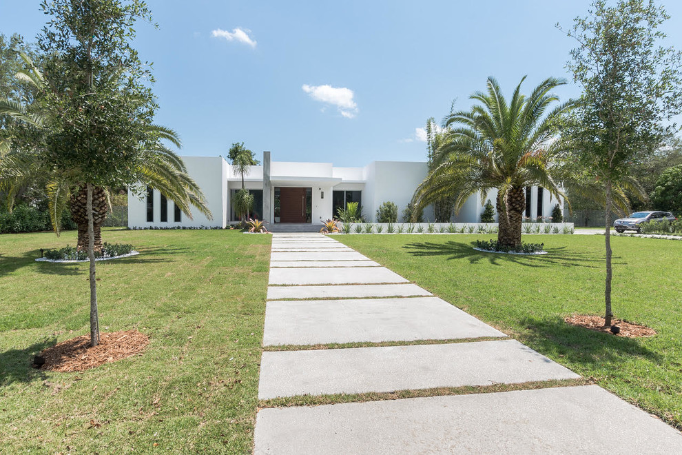 Großes, Einstöckiges Modernes Einfamilienhaus mit Betonfassade, weißer Fassadenfarbe und Flachdach in Miami