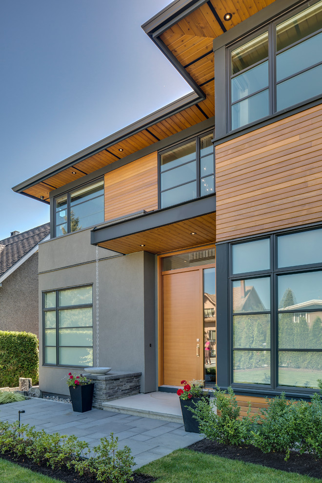 Medium sized and brown traditional house exterior in Vancouver with three floors and mixed cladding.
