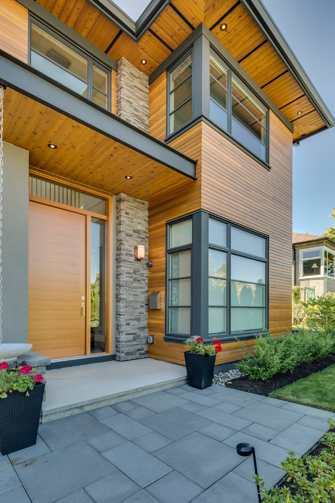 Medium sized and brown classic two floor house exterior in Vancouver with wood cladding.