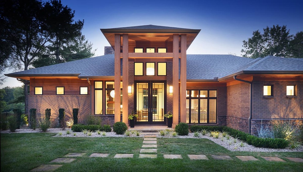 Inspiration pour une façade de maison rouge design en brique à un étage avec un toit à quatre pans.