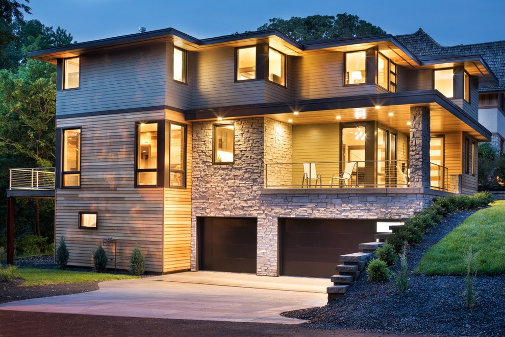 Стильный дизайн: огромный, двухэтажный, разноцветный частный загородный дом в стиле модернизм с комбинированной облицовкой, вальмовой крышей и крышей из смешанных материалов - последний тренд
