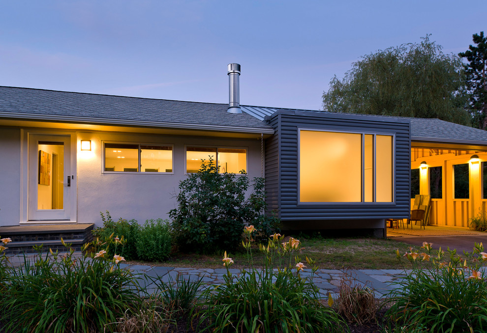 На фото: одноэтажный, бежевый дом в современном стиле с облицовкой из металла и двускатной крышей