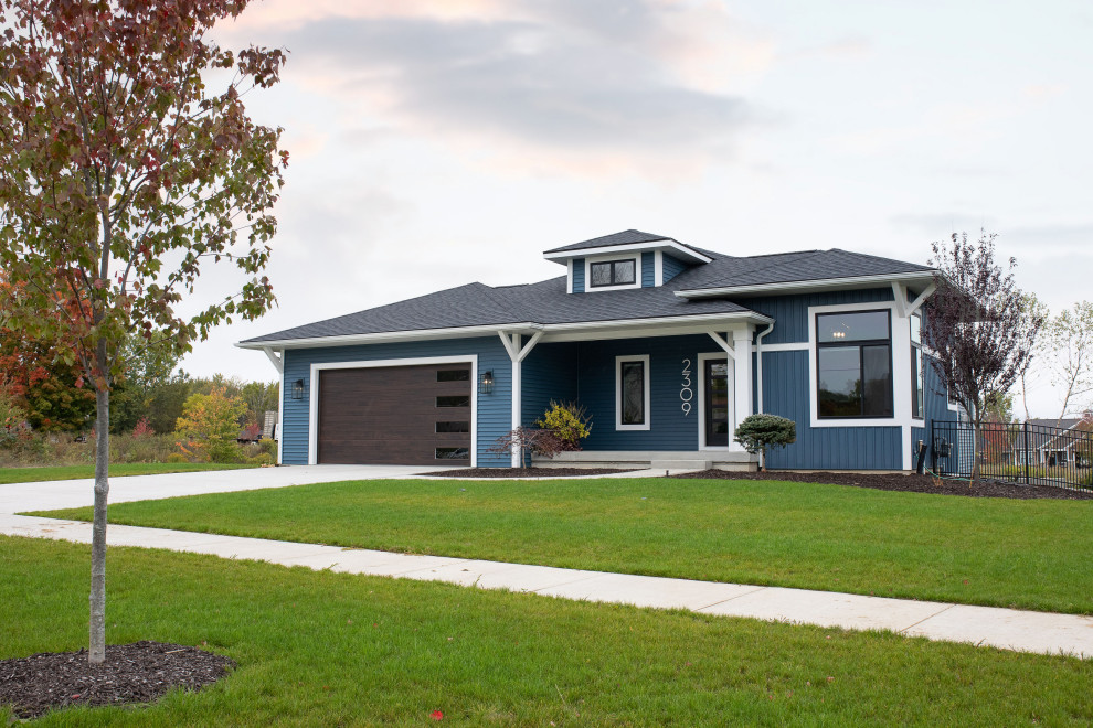 Idée de décoration pour une façade de maison bleue design en planches et couvre-joints de plain-pied avec un revêtement en vinyle, un toit à quatre pans, un toit en shingle et un toit noir.