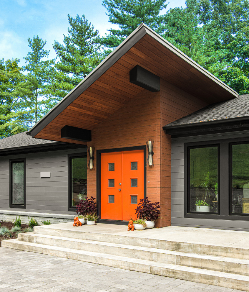 Réalisation d'une façade de maison grise design à un étage avec un toit en appentis, un toit mixte et un toit gris.