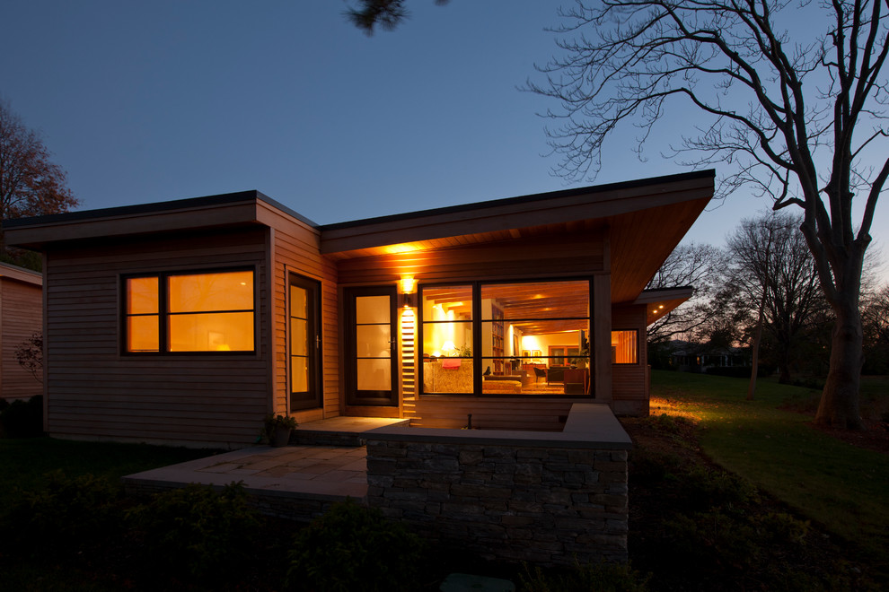 Diseño de fachada de casa marrón contemporánea grande de una planta con revestimiento de madera y tejado plano