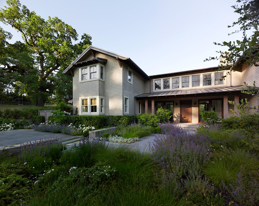 Foto de fachada beige de estilo americano de dos plantas con revestimiento de madera y tejado a cuatro aguas