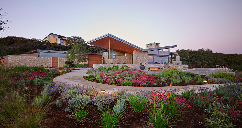 Imagen de fachada beige moderna de tamaño medio de dos plantas con revestimiento de estuco y tejado a doble faldón